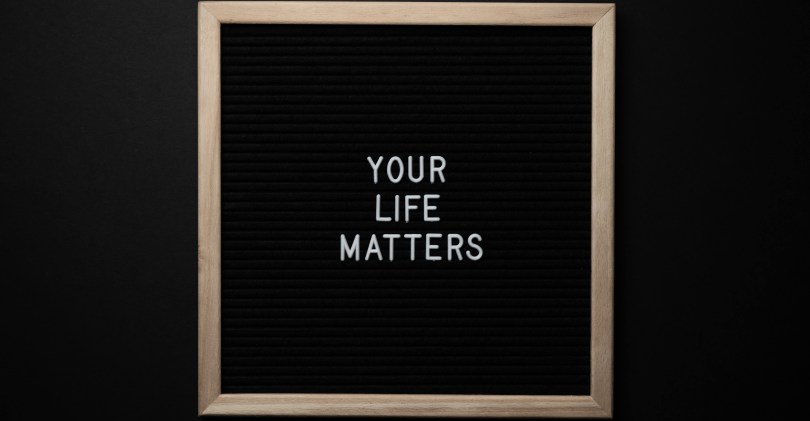 A black letterboard with white capital letters spelling "your life matters" with each word on a separate line