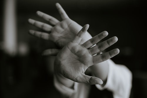 person-extending-hands-with-open-palms-in-stop-gesture-as-contamination-ocd-concept-in-black-and-white