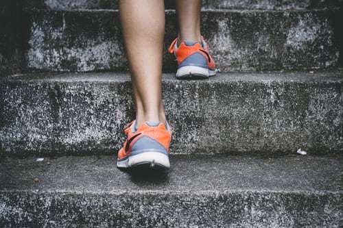 woman running shoes running up concrete staircase