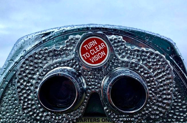 coin-operated-binoculars-with-raindrops-on-surface-and-red-knob-reading-turn-to-clear-vision