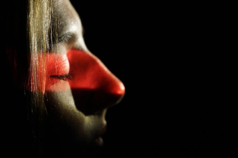 woman face in profile with eyes closed against dark background