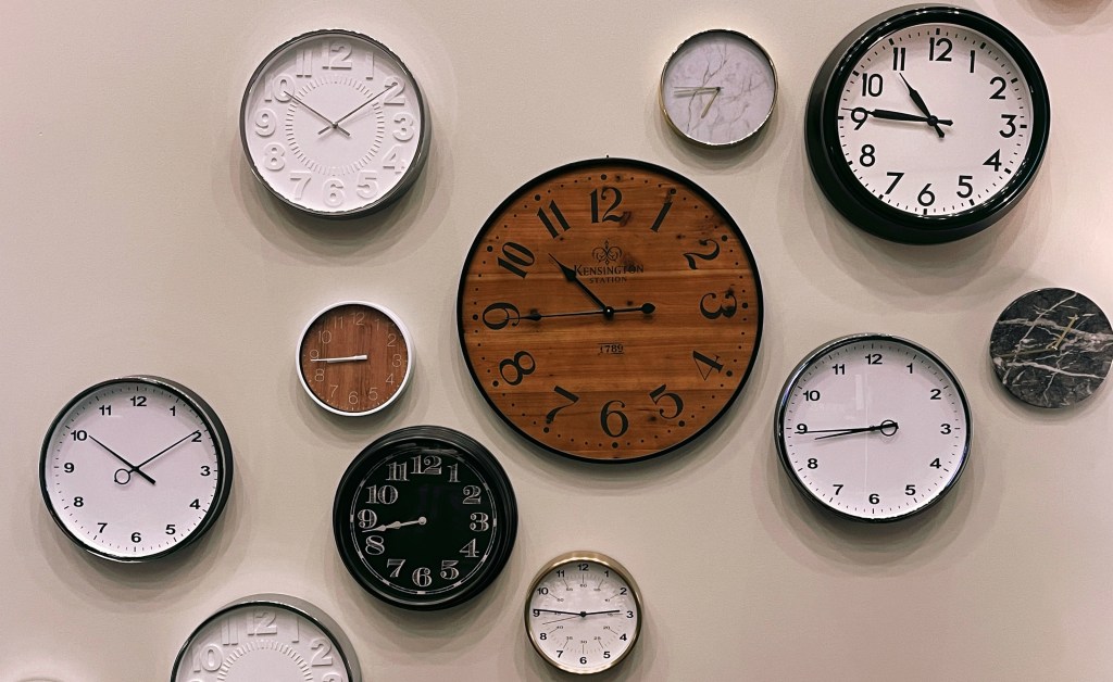An assortment of round analog clocks arranged on a wall