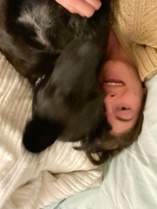 upside-down photo of woman and black dog lying next to each other showing movement in photo