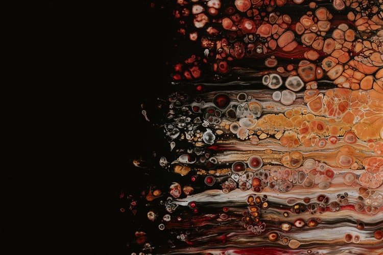 Abstract orange, red, and yellow paint bubbles on a black background