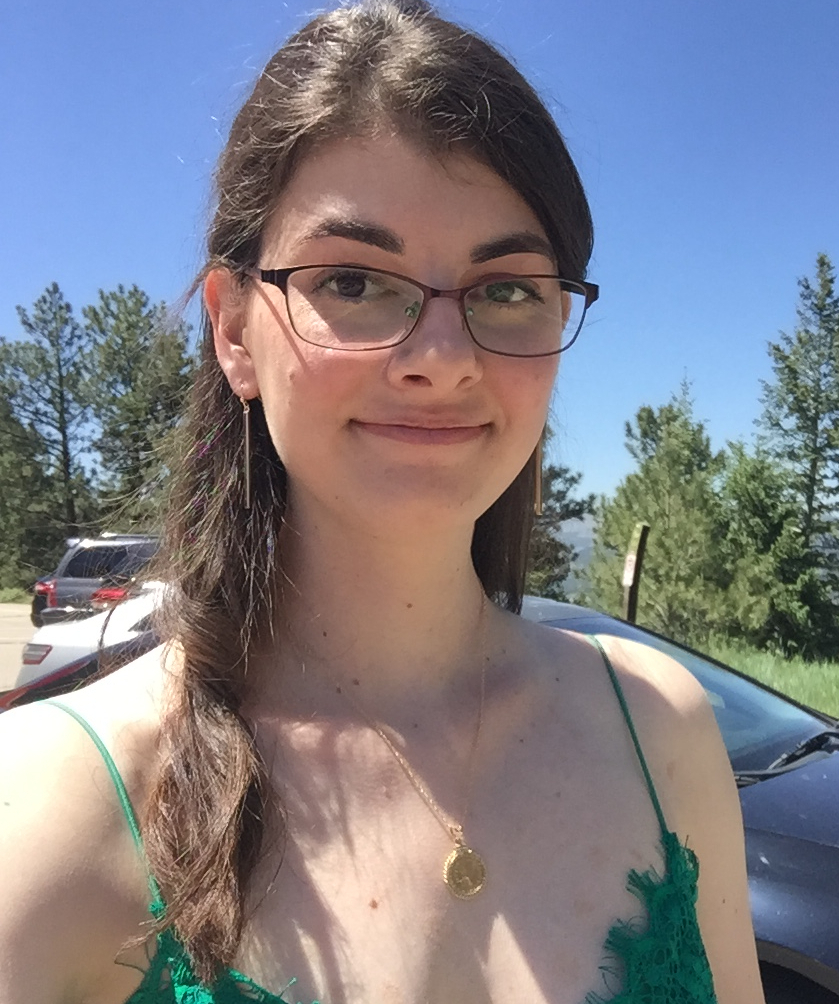 A woman wearing glasses and a low-cut dress with spaghetti straps